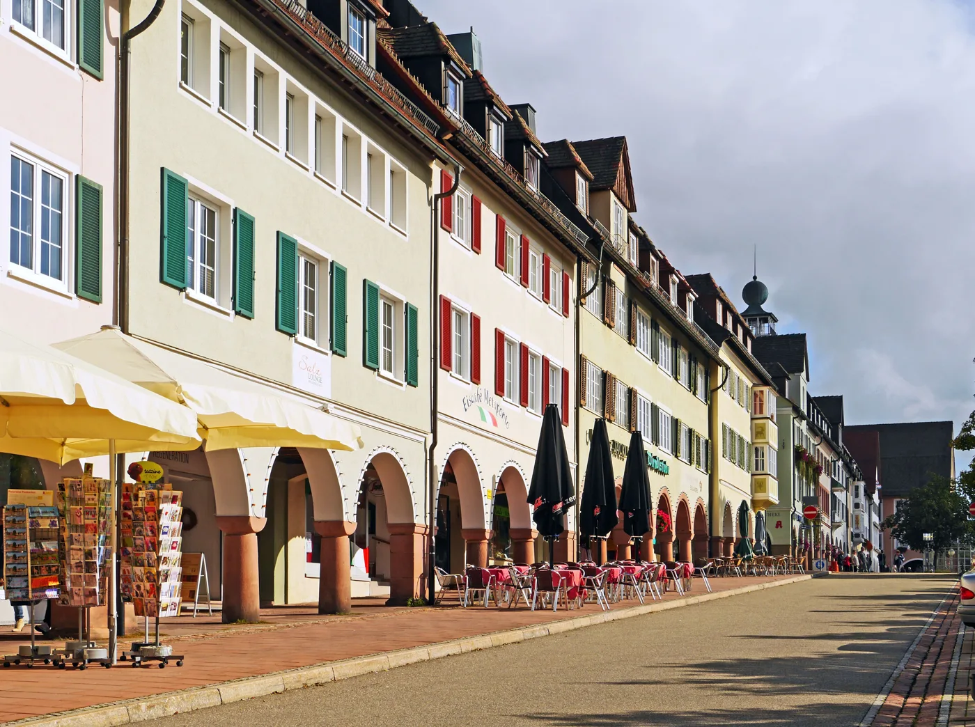 Eine Arkadengasse mit Geschäften und Cafés
