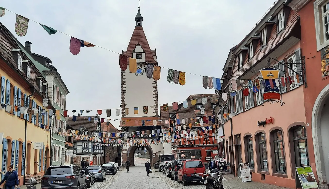 Das festlich beflaggte Stadttor über der Gasse