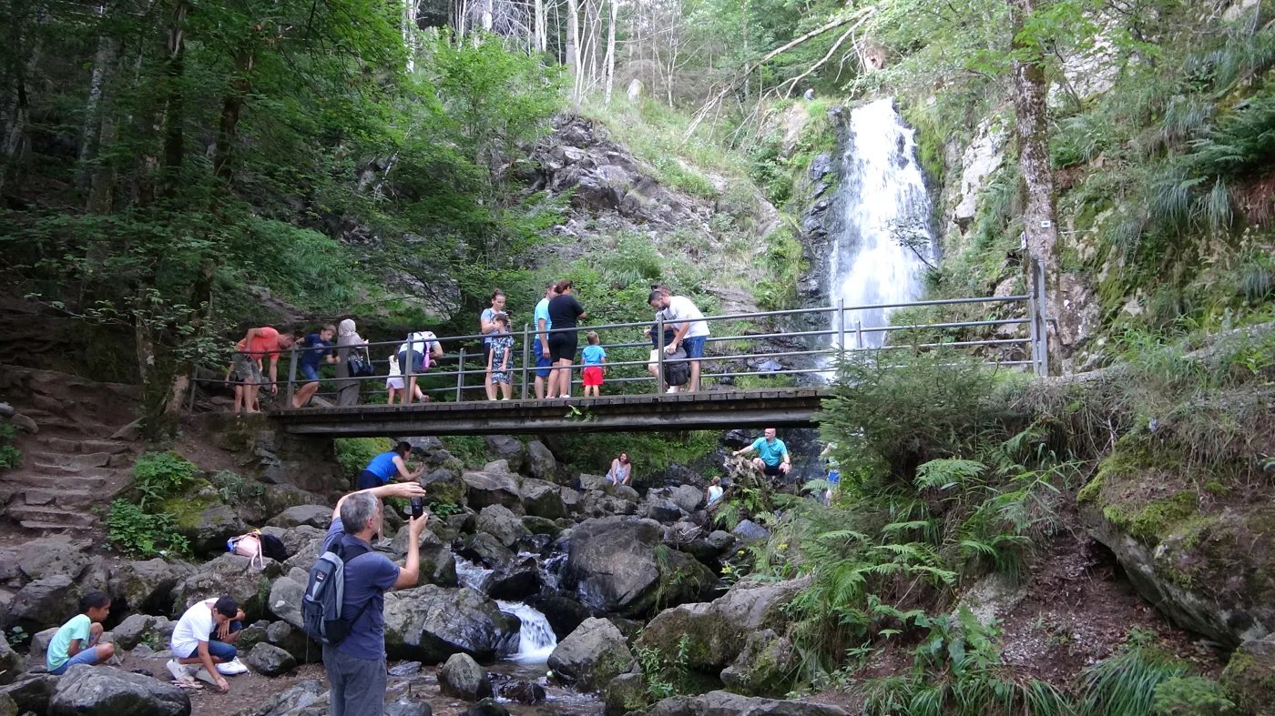 Besucher am Fuß des tosenden Wasserfalls