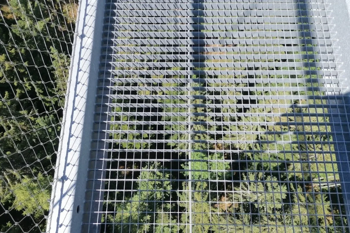 Der Blick durch den Gitterrost tief hinab in den Wald