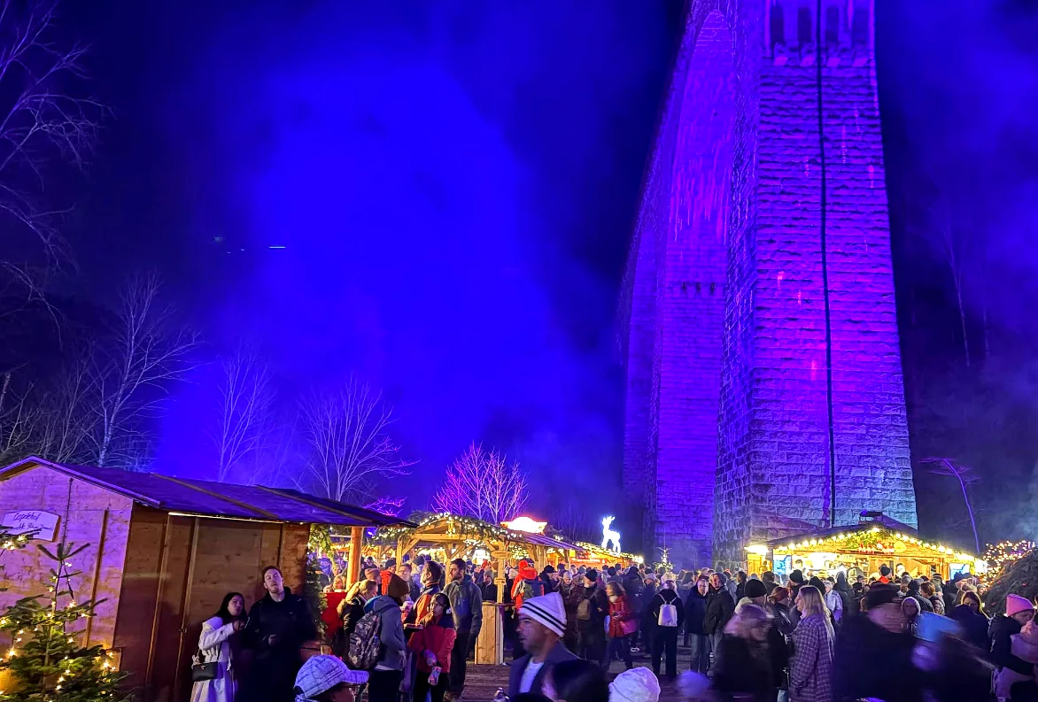 Weihnachtsmarktstände unter dem blau beleuchteten Ravenna-Viadukt mit vielen Besuchern